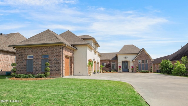 121 Snapping Ln, Broussard, LA 70518 - french country home featuring concrete driveway, a front yard, brick siding, and roof with shingles