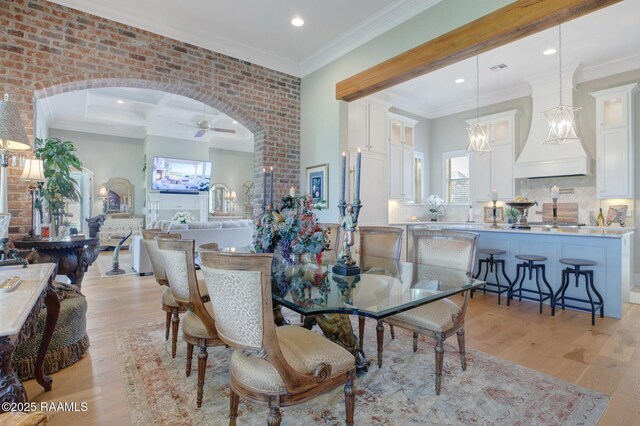 121 Snapping Ln, Broussard, LA 70518 - dining space with healthy amount of natural light, light wood-style flooring, a ceiling fan, ornamental molding, and arched walkways
