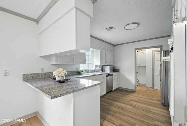 301 Estainville Ave, Lafayette, LA 70508 - kitchen with crown molding, stainless steel appliances, a peninsula, light wood-style floors, and a textured ceiling