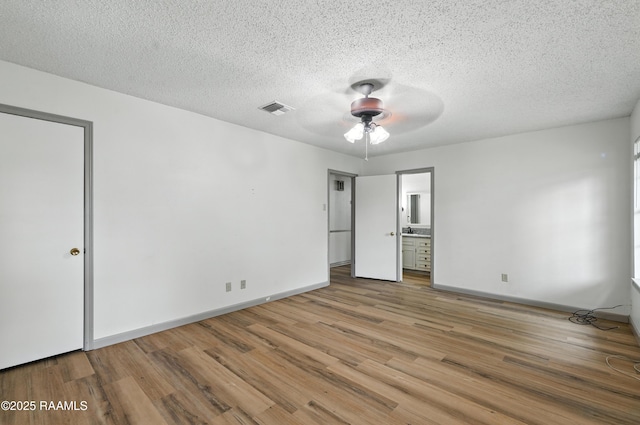 301 Estainville Ave, Lafayette, LA 70508 - unfurnished bedroom with wood finished floors, a textured ceiling, connected bathroom, and a ceiling fan
