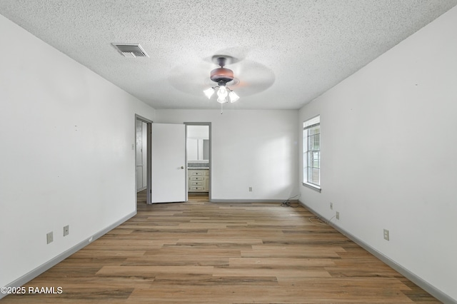 301 Estainville Ave, Lafayette, LA 70508 - unfurnished bedroom featuring wood finished floors, a textured ceiling, and ensuite bath