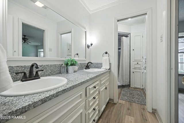 301 Estainville Ave, Lafayette, LA 70508 - bathroom featuring wood finished floors, crown molding, double vanity, and ceiling fan