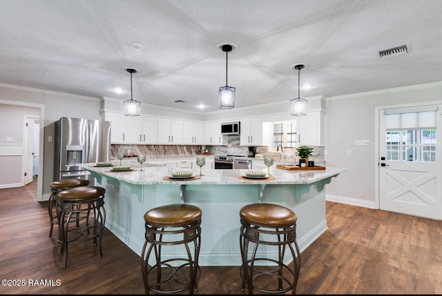 381 Rue Dauphine, Eunice, LA 70535 - kitchen with stainless steel appliances, white cabinetry, backsplash, dark wood-style flooring, and ornamental molding