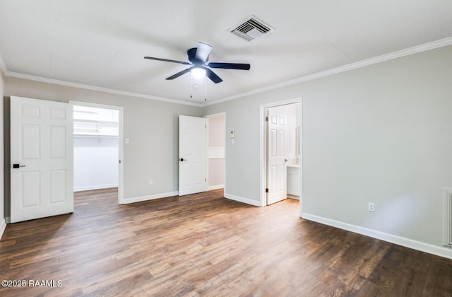 381 Rue Dauphine, Eunice, LA 70535 - unfurnished bedroom with wood finished floors, ornamental molding, a walk in closet, and connected bathroom