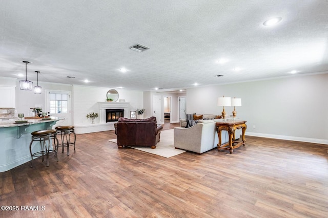 381 Rue Dauphine, Eunice, LA 70535 - living area with recessed lighting, wood finished floors, crown molding, and a glass covered fireplace