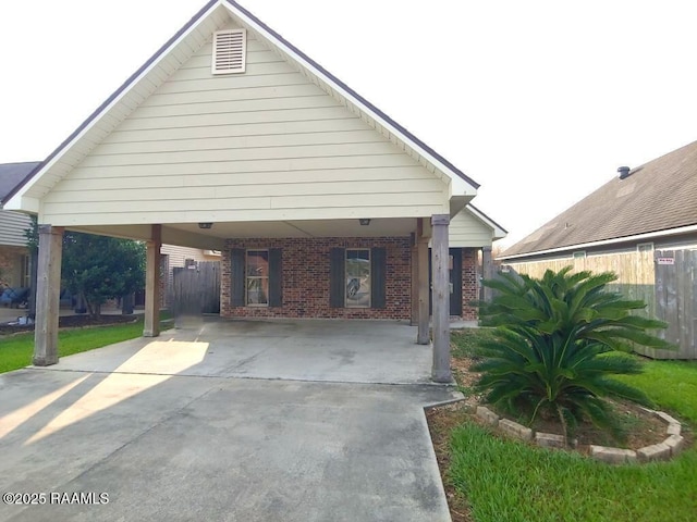 120 Acacia Ln, Abbeville, LA 70510 - view of front of house with brick siding, driveway, and an attached carport