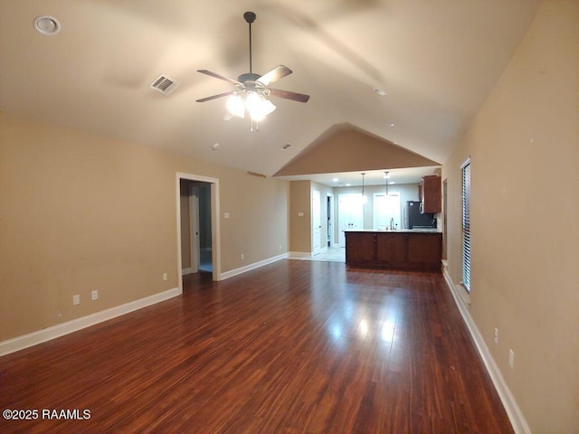 120 Acacia Ln, Abbeville, LA 70510 - unfurnished living room featuring a ceiling fan, vaulted ceiling, and dark wood-type flooring