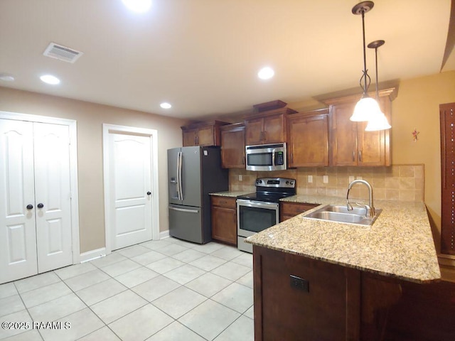 120 Acacia Ln, Abbeville, LA 70510 - kitchen featuring stainless steel appliances, tasteful backsplash, light tile patterned floors, hanging light fixtures, and a peninsula