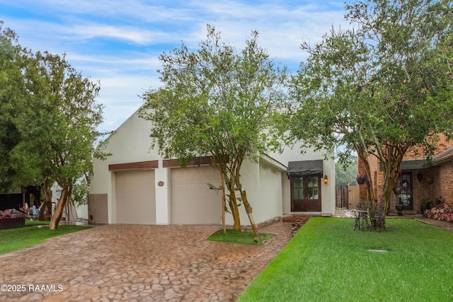 115 Breckenridge Loop, Lafayette, LA 70506 - view of front of house featuring decorative driveway, a front yard, a garage, and stucco siding