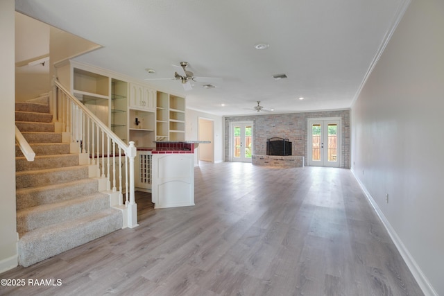 115 Breckenridge Loop, Lafayette, LA 70506 - unfurnished living room featuring french doors, a ceiling fan, crown molding, stairs, and wood finished floors