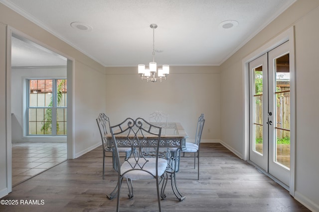 115 Breckenridge Loop, Lafayette, LA 70506 - dining room with healthy amount of natural light, ornamental molding, french doors, a chandelier, and wood finished floors