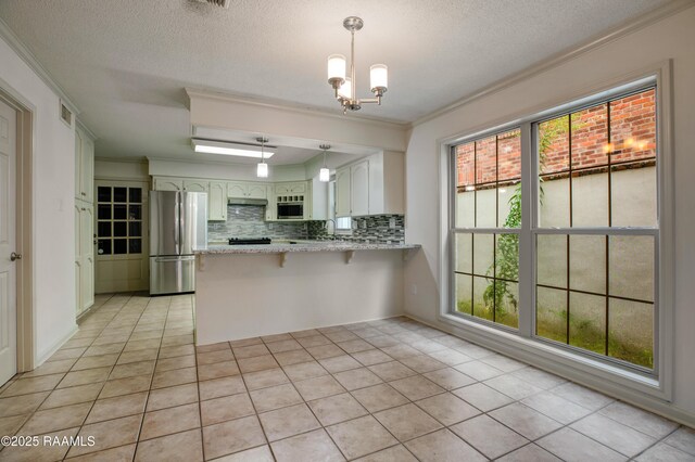 115 Breckenridge Loop, Lafayette, LA 70506 - kitchen with appliances with stainless steel finishes, a peninsula, ornamental molding, decorative backsplash, and a chandelier