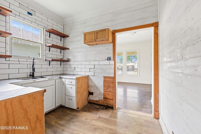 617 E Vermillion St, Lafayette, LA 70501 - kitchen with crown molding, wood finished floors, open shelves, light countertops, and tasteful backsplash