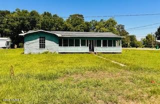 1627 Daniel St, Abbeville, LA 70510 - view of front of house with a front yard and a sunroom