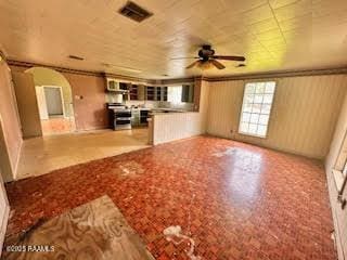 1627 Daniel St, Abbeville, LA 70510 - unfurnished living room featuring arched walkways and ceiling fan