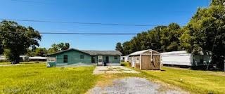1627 Daniel St, Abbeville, LA 70510 - view of front of house featuring dirt driveway, a front lawn, and an outbuilding