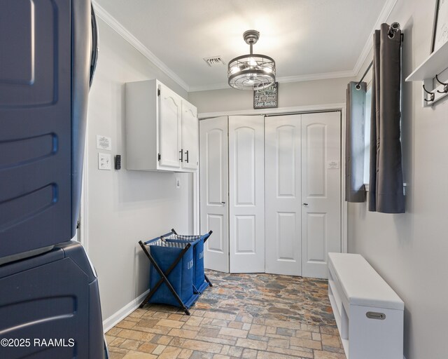 809 Dartez Dr, New Iberia, LA 70563 - mudroom featuring brick flooring, ornamental molding, and stacked washing machine and dryer