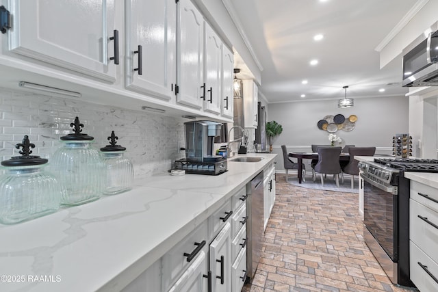809 Dartez Dr, New Iberia, LA 70563 - kitchen with appliances with stainless steel finishes, white cabinets, decorative backsplash, ornamental molding, and recessed lighting