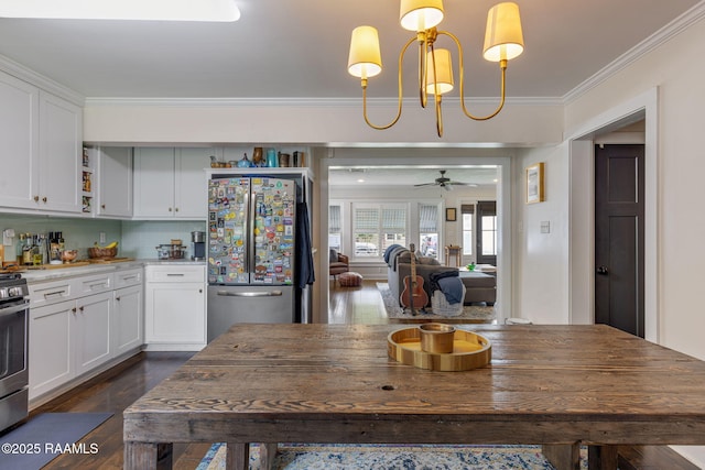 234 Ridgewood St, Lafayette, LA 70506 - kitchen featuring appliances with stainless steel finishes, crown molding, white cabinetry, dark wood-style floors, and decorative light fixtures