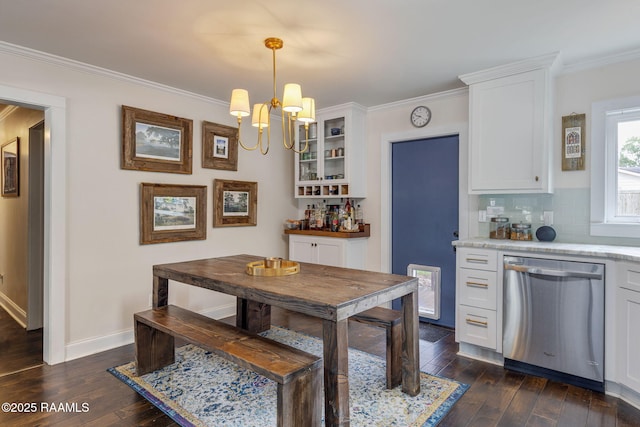 234 Ridgewood St, Lafayette, LA 70506 - dining space with a chandelier, dark wood finished floors, ornamental molding, and a bar
