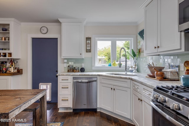 234 Ridgewood St, Lafayette, LA 70506 - kitchen featuring appliances with stainless steel finishes, dark wood-style floors, white cabinetry, backsplash, and ornamental molding