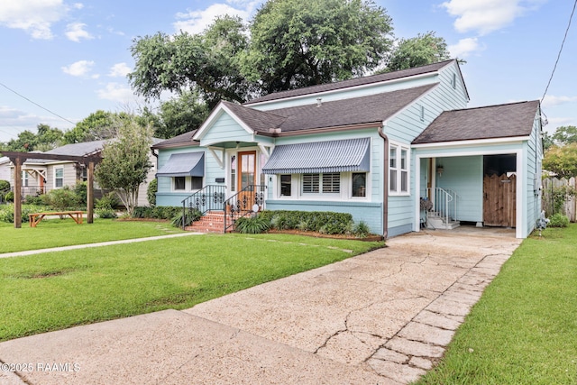 234 Ridgewood St, Lafayette, LA 70506 - view of front facade featuring driveway, a front lawn, a shingled roof, and an attached carport