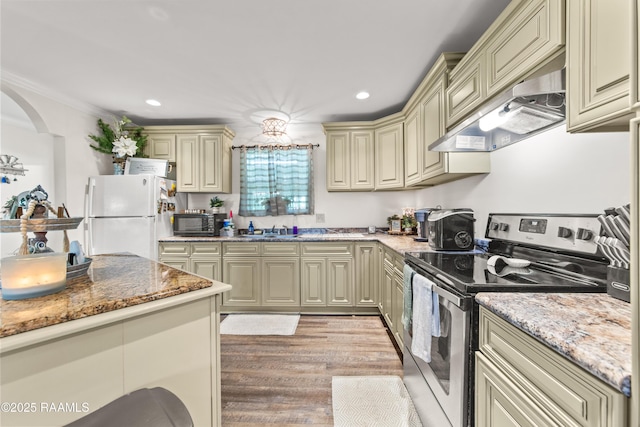 1329-B Grand Anse Hwy, Breaux Bridge, LA 70517 - kitchen featuring cream cabinetry, freestanding refrigerator, stainless steel electric range oven, wall chimney exhaust hood, and recessed lighting