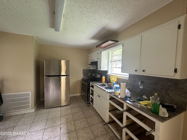 7226 Meadowview Ave, Baton Rouge, LA 70810 - kitchen with stainless steel appliances, a textured ceiling, white cabinetry, decorative backsplash, and light tile patterned floors