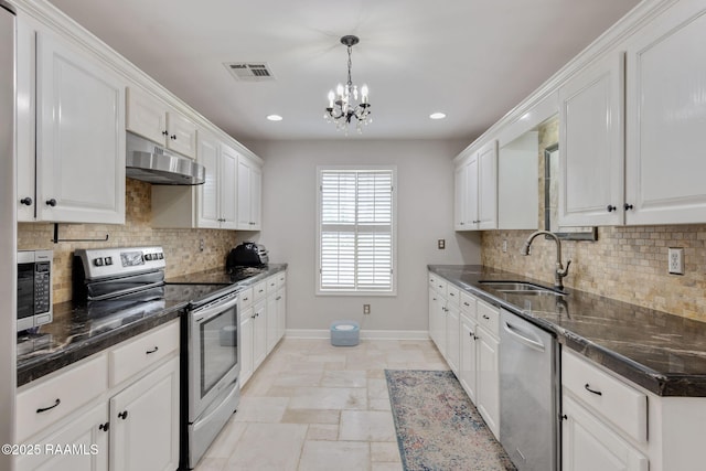 921 Bellevue Plantation Rd, Lafayette, LA 70503 - kitchen featuring appliances with stainless steel finishes, under cabinet range hood, white cabinetry, a chandelier, and recessed lighting