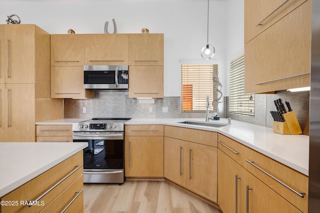 3703 Daspit Rd, New Iberia, LA 70563 - kitchen featuring stainless steel appliances, light countertops, backsplash, light wood-style floors, and light brown cabinets