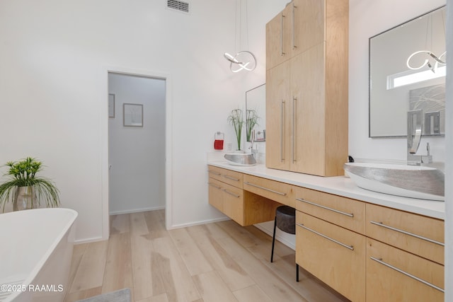 3703 Daspit Rd, New Iberia, LA 70563 - bathroom featuring a freestanding tub, double vanity, and wood finished floors