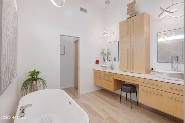 3703 Daspit Rd, New Iberia, LA 70563 - bathroom featuring wood finished floors, a freestanding bath, and double vanity