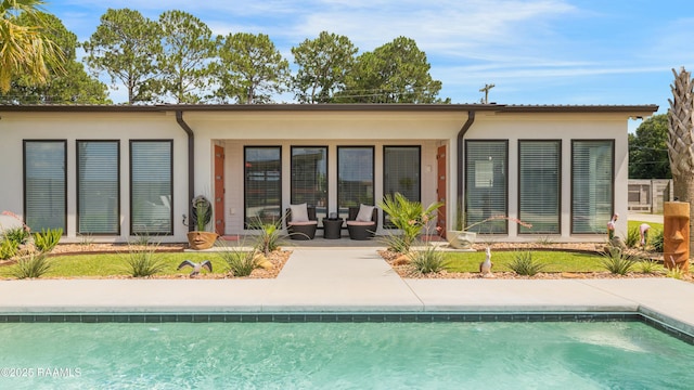 3703 Daspit Rd, New Iberia, LA 70563 - back of property featuring an outdoor pool, stucco siding, and a patio