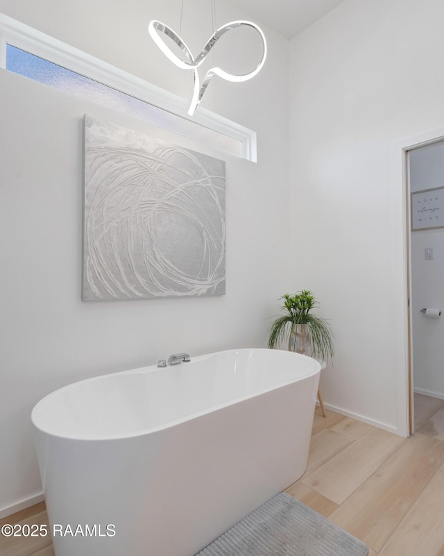 3703 Daspit Rd, New Iberia, LA 70563 - full bathroom with wood finished floors, a soaking tub, and a chandelier