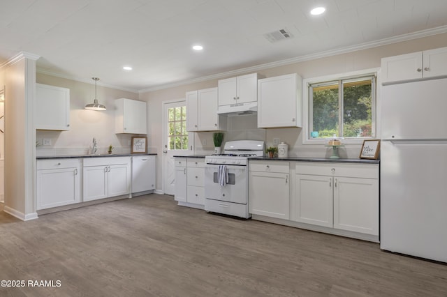 109 Guadalajara St, New Iberia, LA 70563 - kitchen featuring white appliances, under cabinet range hood, ornamental molding, dark countertops, and white cabinetry