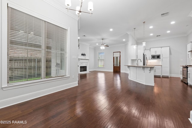 106 Whitewater Dr, Broussard, LA 70518 - unfurnished living room featuring crown molding, dark wood-type flooring, a chandelier, a glass covered fireplace, and recessed lighting