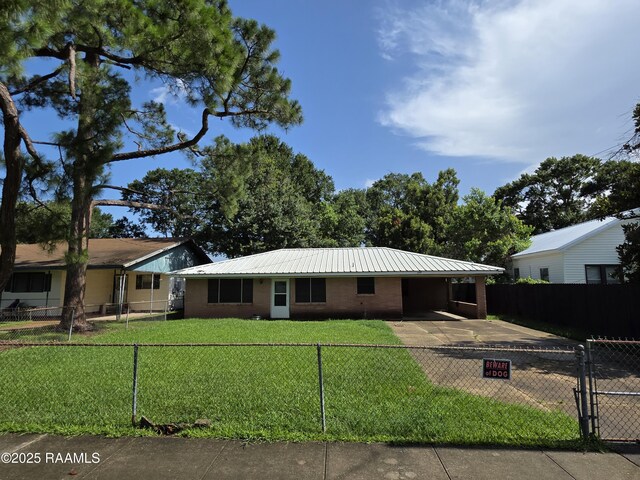 119 Romero St, Youngsville, LA 70592 - ranch-style house featuring a carport, a fenced front yard, and a metal roof