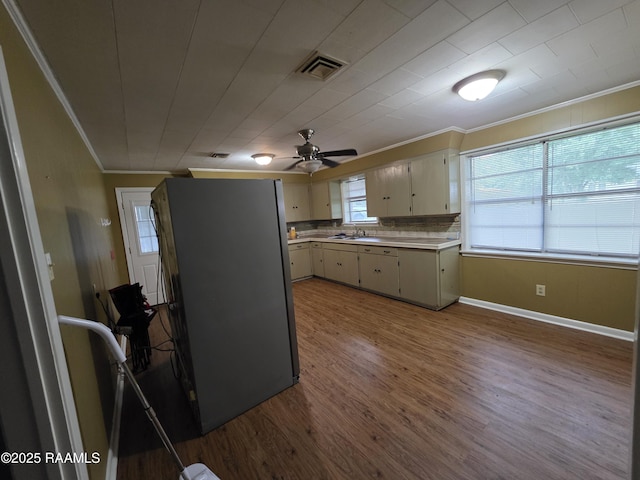 119 Romero St, Youngsville, LA 70592 - kitchen featuring ornamental molding, light countertops, wood finished floors, ceiling fan, and backsplash