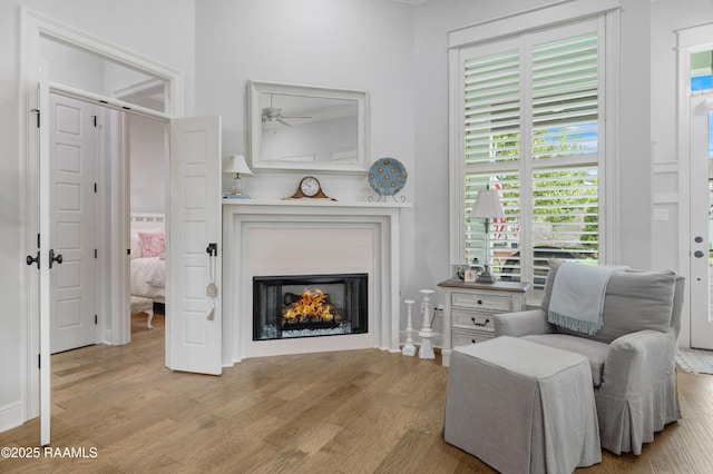 403 Catalina Ln, Youngsville, LA 70592 - living area featuring wood finished floors, a lit fireplace, and ceiling fan
