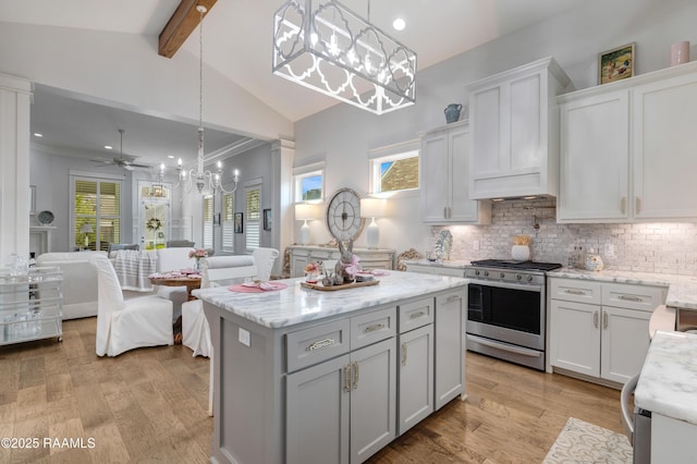 403 Catalina Ln, Youngsville, LA 70592 - kitchen with stainless steel gas range oven, open floor plan, decorative backsplash, a kitchen island, and white cabinetry
