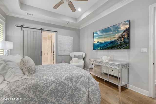 403 Catalina Ln, Youngsville, LA 70592 - bedroom with a barn door, a tray ceiling, wood finished floors, ceiling fan, and recessed lighting