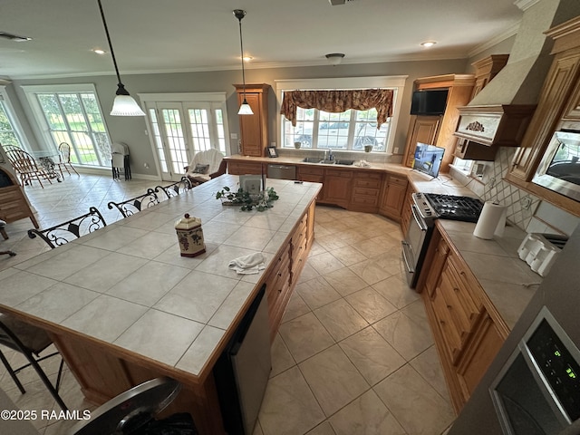 14439 Gladu Rd, Kaplan, LA 70548 - kitchen featuring tile countertops, stainless steel appliances, ornamental molding, pendant lighting, and backsplash