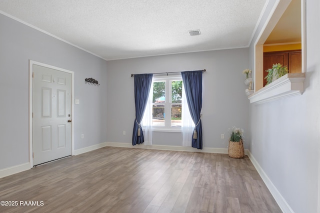 101 Sherry St, Baldwin, LA 70514 - spare room featuring light wood-style flooring, a textured ceiling, and crown molding