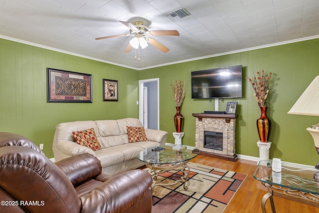 522 Caroline St, New Iberia, LA 70560 - living room featuring ceiling fan, wood finished floors, ornamental molding, and a stone fireplace