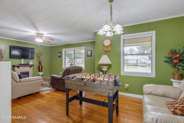 522 Caroline St, New Iberia, LA 70560 - game room with ornamental molding, light wood finished floors, a chandelier, a fireplace, and a ceiling fan