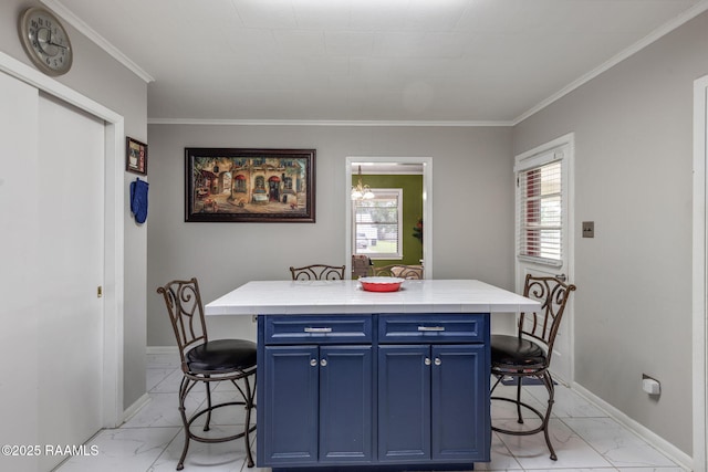 522 Caroline St, New Iberia, LA 70560 - kitchen featuring light marble finish floors, blue cabinets, a breakfast bar area, crown molding, and light countertops