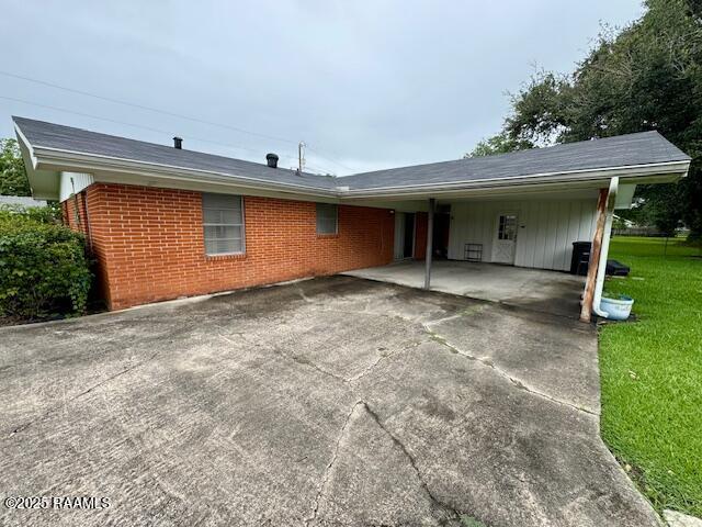 110 W Tampico St, New Iberia, LA 70563 - view of front of home featuring brick siding, concrete driveway, a front lawn, and an attached carport