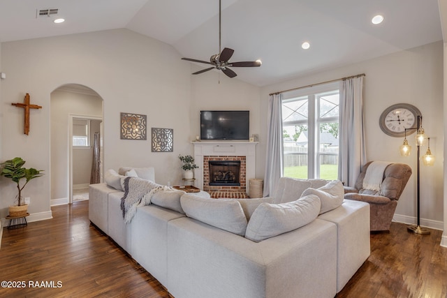 203 Whispering Meadows Rd, Broussard, LA 70518 - living room featuring lofted ceiling, arched walkways, ceiling fan, dark wood-style flooring, and a fireplace