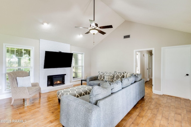 13723 Lynnedale Loop, Abbeville, LA 70510 - living room with ceiling fan, light wood-style floors, high vaulted ceiling, and a fireplace
