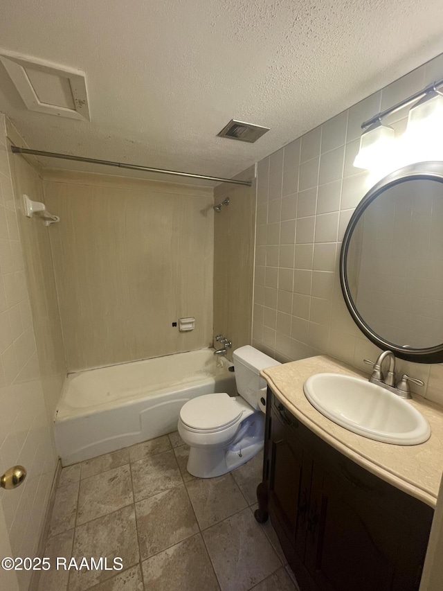 3121 Johnston St Apt 139, Lafayette, LA 70503 - full bath with tile walls, vanity, washtub / shower combination, and a textured ceiling